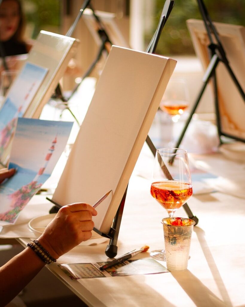 People enjoy painting and drinking wine.