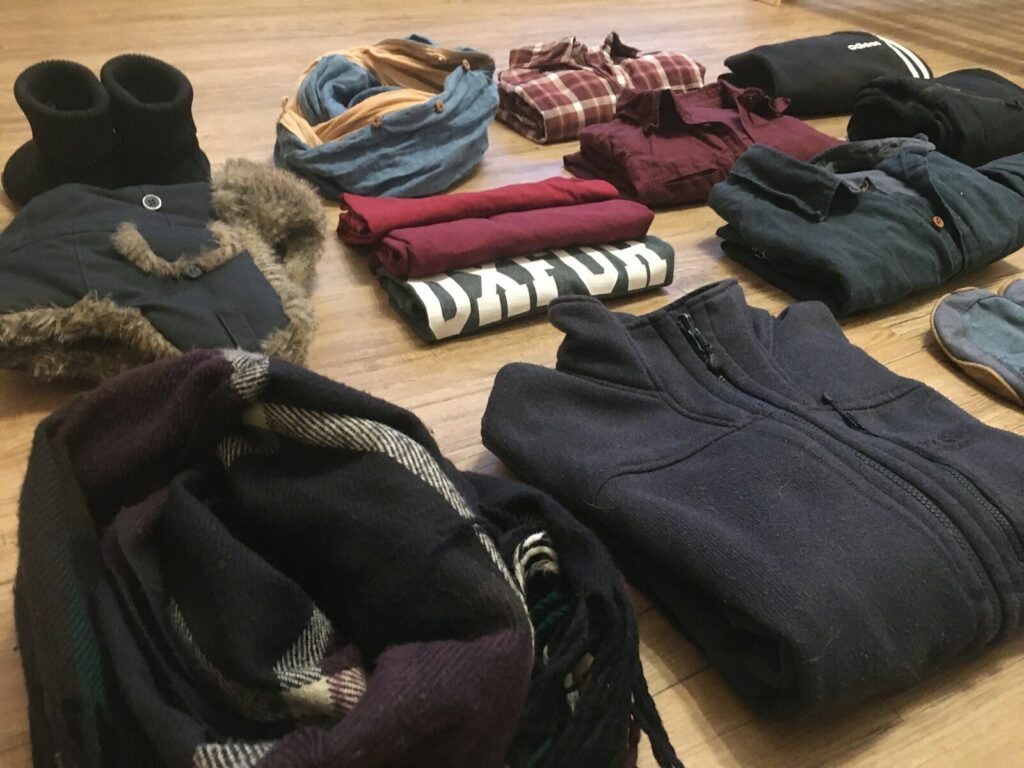 a pile of clothes sitting on top of a wooden floor