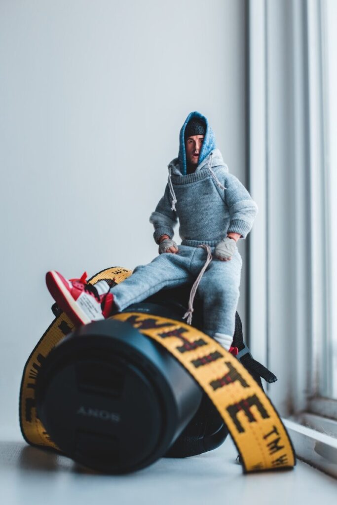 a toy figure sitting on top of a trash can