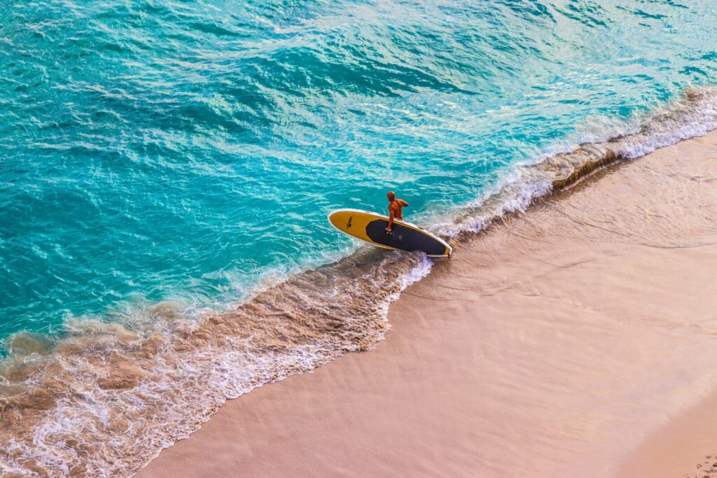 man in yellow surfing board on sea waves during daytime