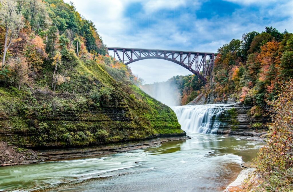 a bridge over a river with a waterfall below