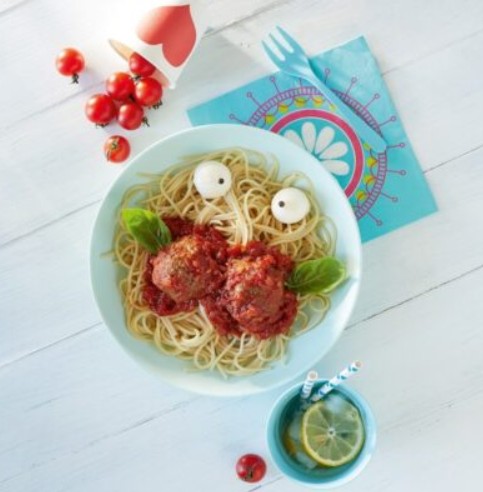 green and white ceramic bowl with pasta and sliced tomato