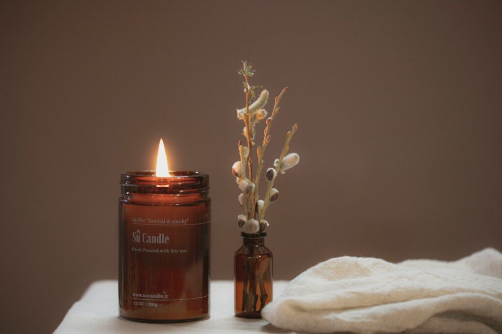 brown pillar candle on brown glass bottle